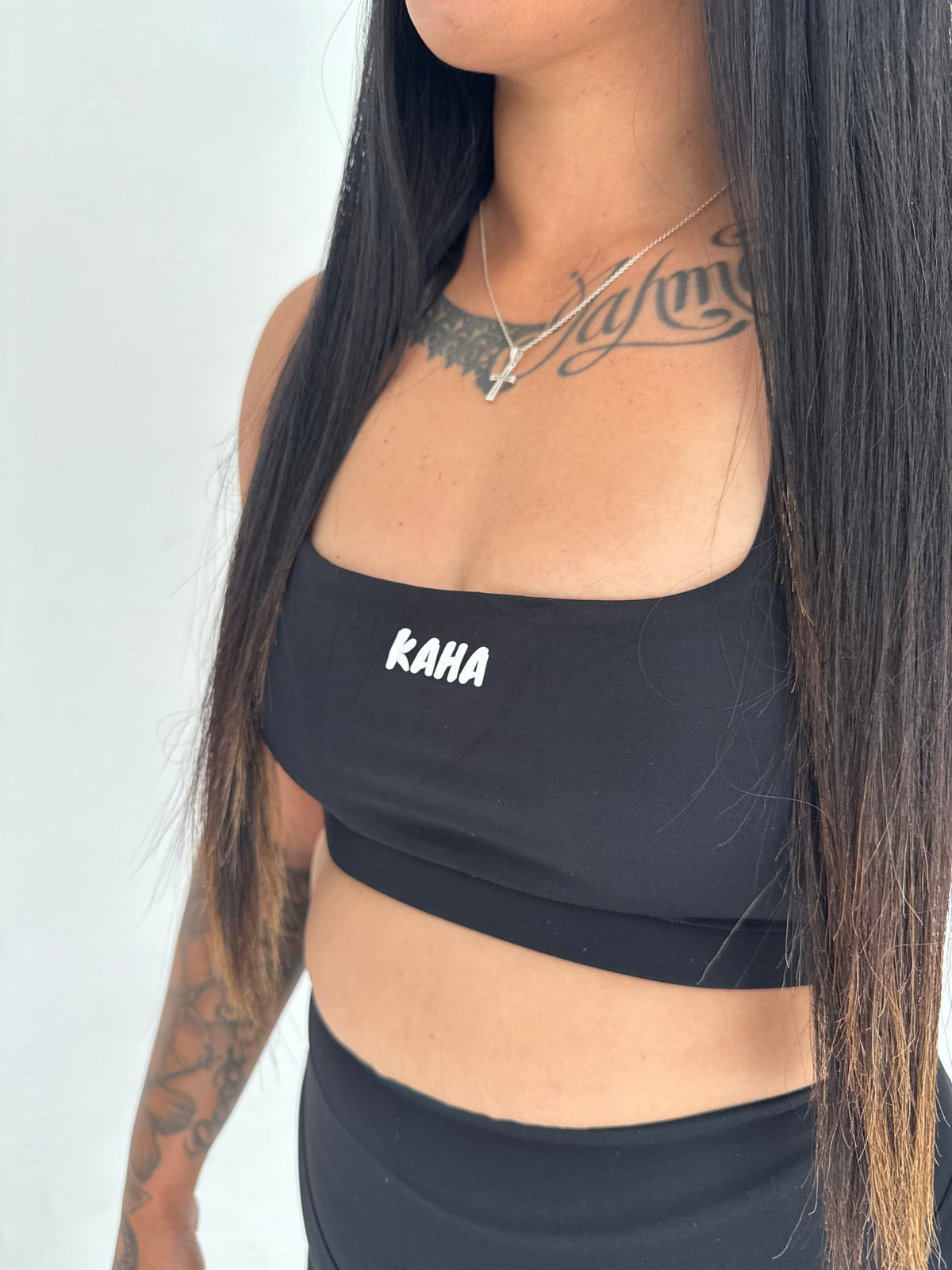 KAHA black athletic crop top with square neckline and white logo on a model