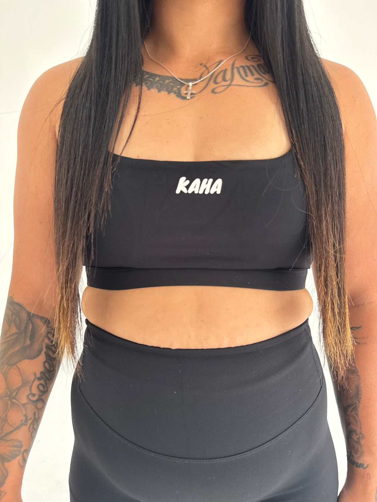 KAHA black athletic sports bra with square neckline and white logo, worn with matching high-waisted shorts