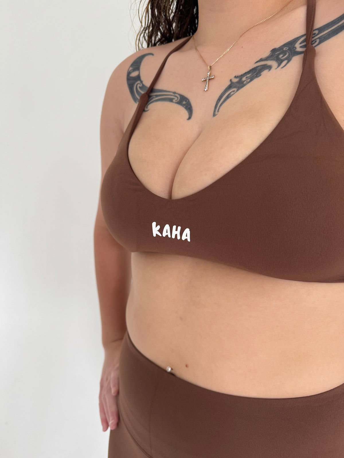 KAHA brown sports bra from a matching set featuring a supportive fit and white brand logo on a woman