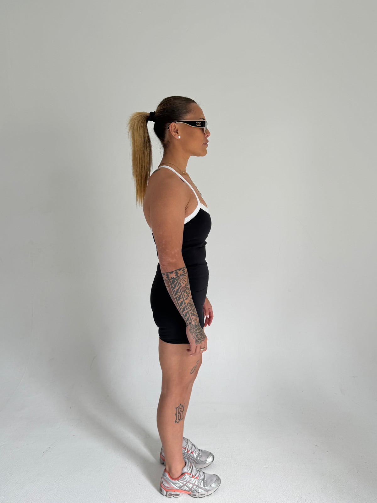 KAHA Onyx Set featuring a black halter sports bra and high-waisted shorts with white trim on a model in profile view.